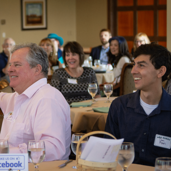 ApplewoodBusinessAssociation_LittleShoeStudios_15 Aba member sitting next to each other and guest smiling