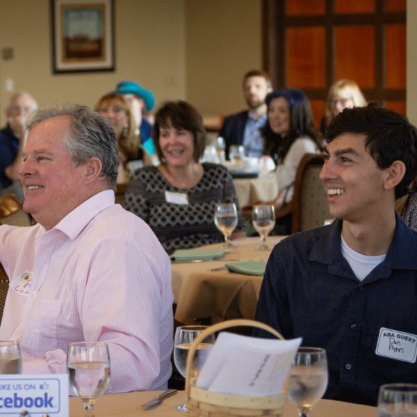 Aba member sitting next to each other and guest smiling